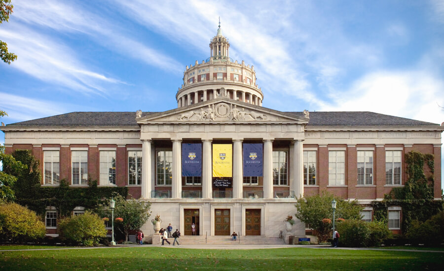 Exterior view of the University of Rochester, Rush Rhee Library building showcasing its architectural design and surrounding landscape.
